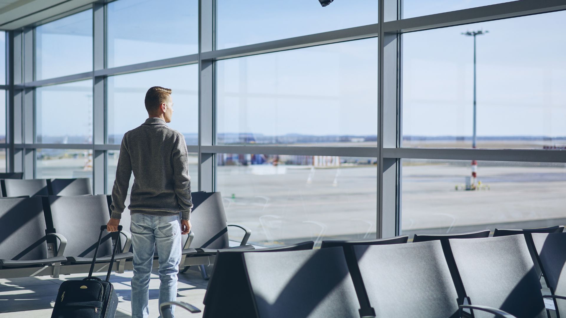 Business traveler walking through an airport terminal before boarding a private charter flight.